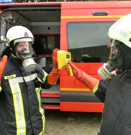 A fireman checking another one's contamination rate with a hand-held contamination monitor