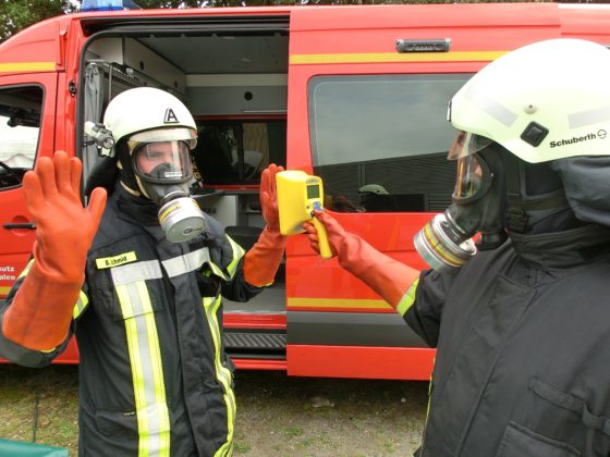 A fireman checking another one's contamination rate with a hand-held contamination monitor