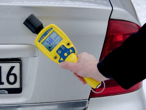 Someone using a high-sensitive gamma radiation monitor on a car