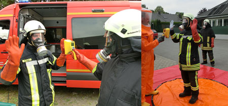 Firemen checking each other's dose rate with hand-held contamination monitors